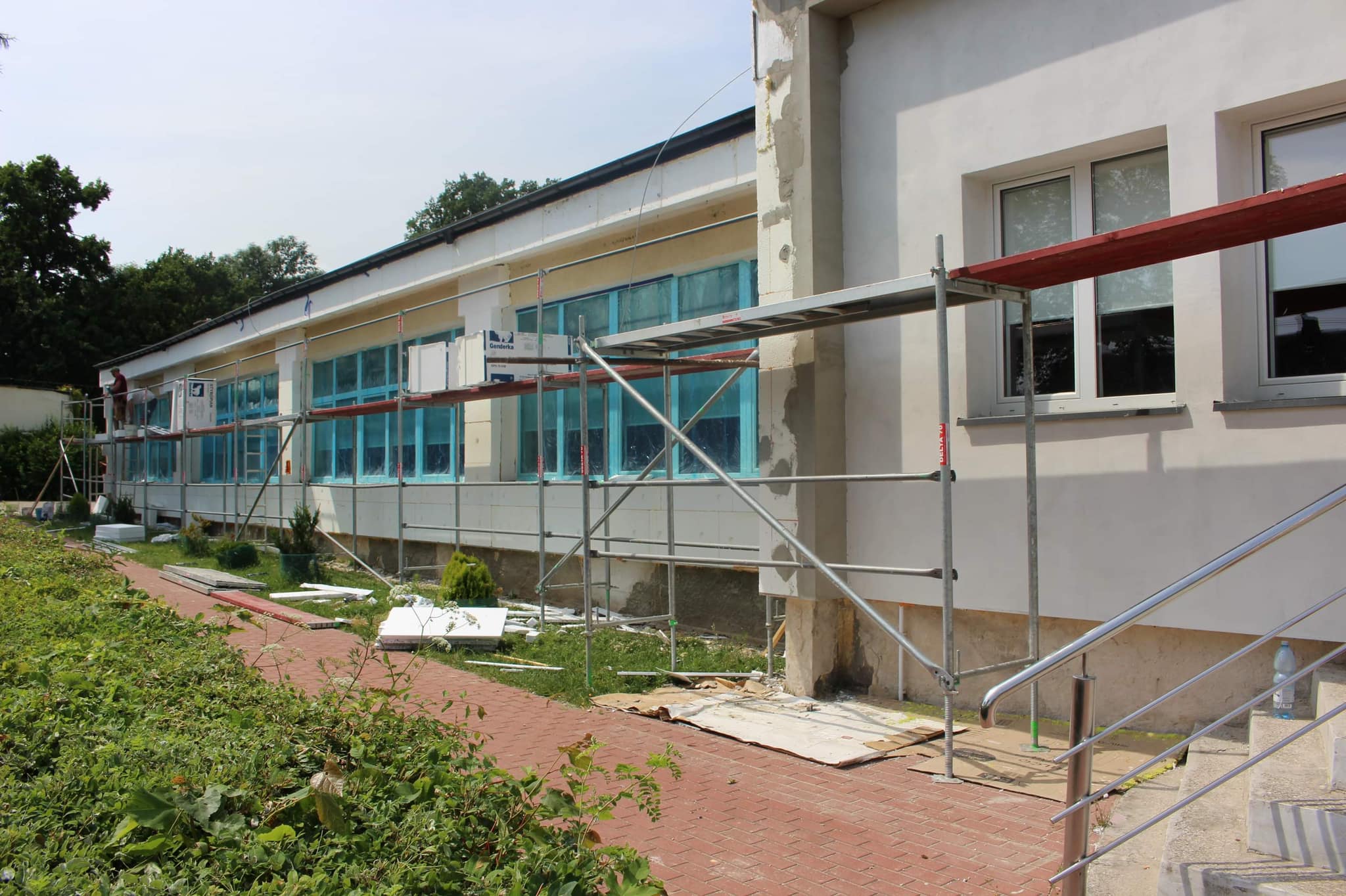 ściana budynku szkoły z nowymi oknami i ścianą obłożoną styropianem