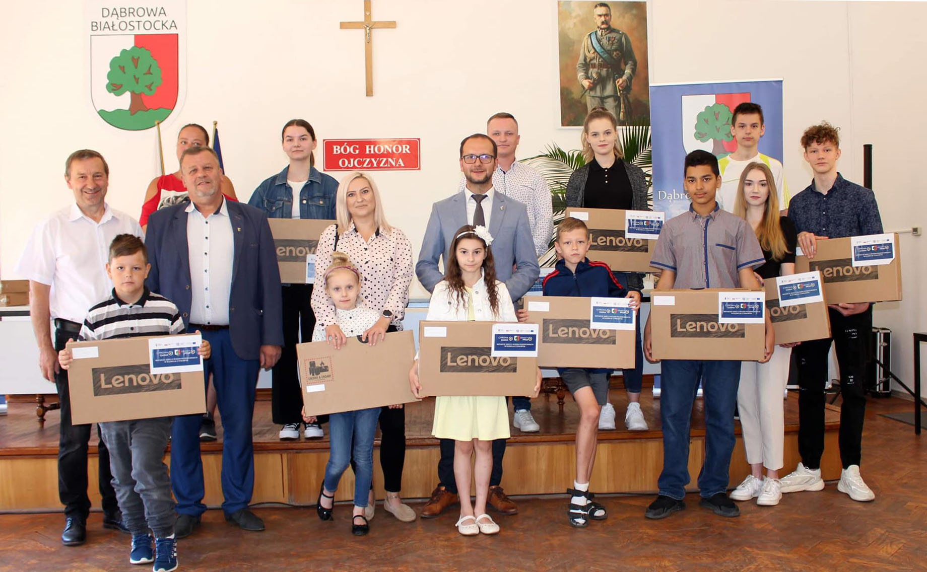 burmistrz z radnymi i dziećmi które otrzymały laptopy