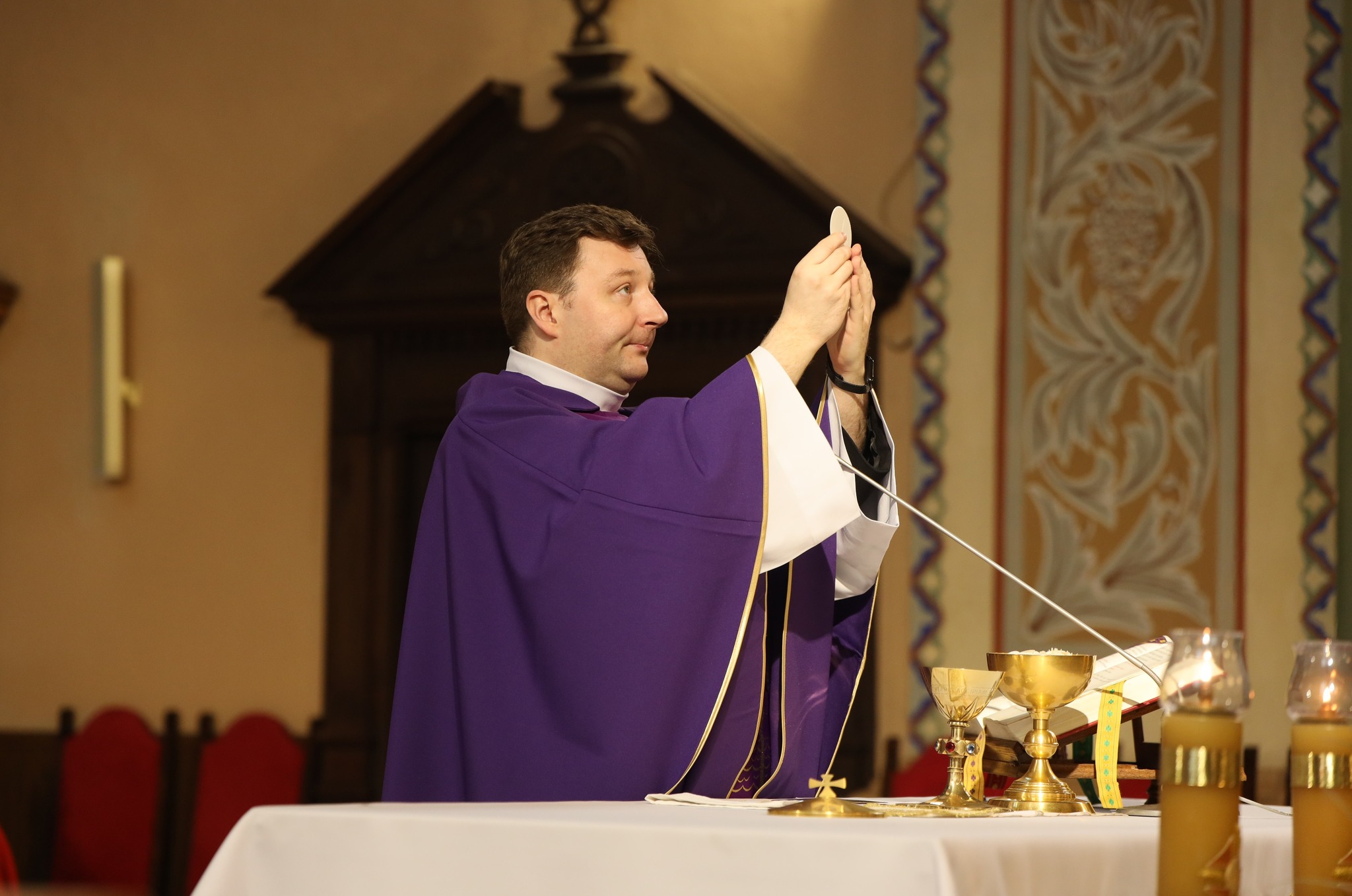 KSIĄDZ TRZYMA HOSTIĘ